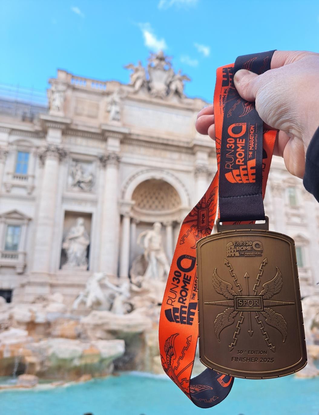 Médaille du marathon de Rome devant la fontaine de Trevi.